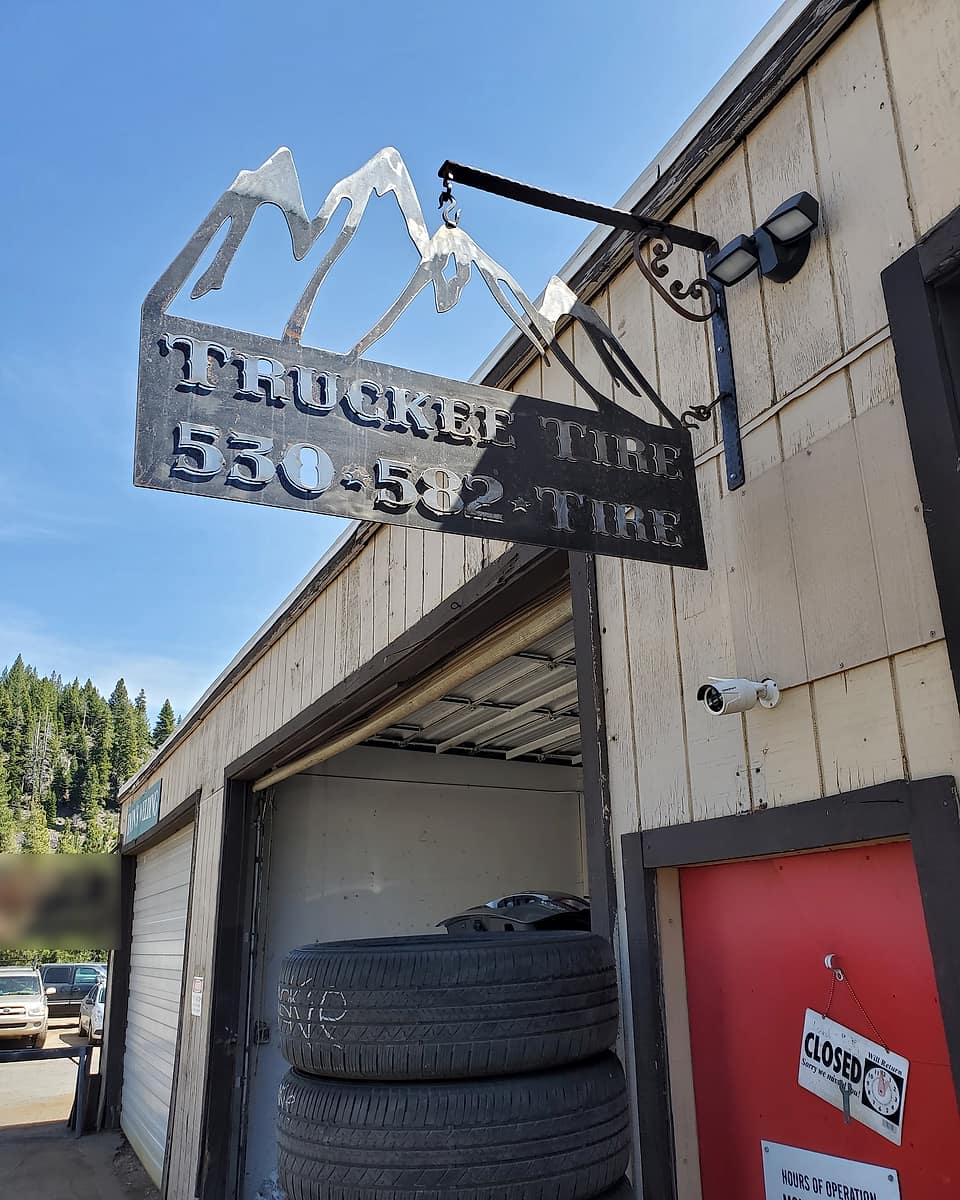 The steel Truckee Tire hanging sign: a cut-out mountain range over the shop name and phone number